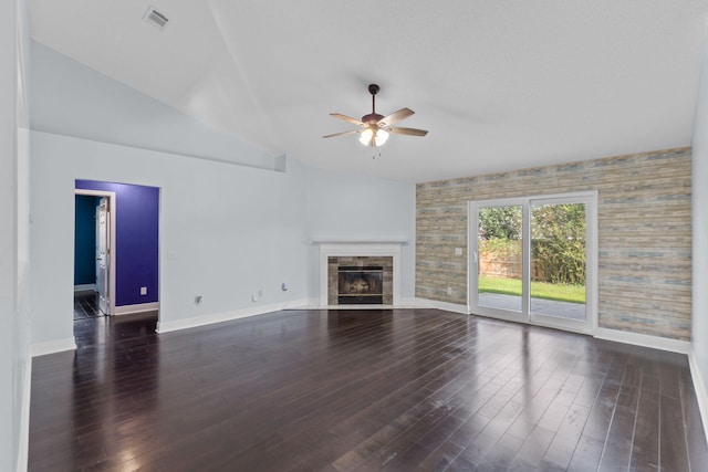 unfurnished living room featuring dark hardwood / wood-style flooring, vaulted ceiling, ceiling fan, and a tiled fireplace