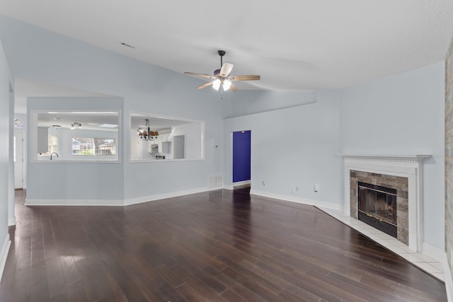 unfurnished living room with ceiling fan with notable chandelier, sink, hardwood / wood-style flooring, lofted ceiling, and a tiled fireplace