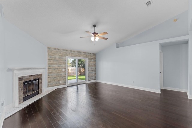 unfurnished living room with lofted ceiling, hardwood / wood-style flooring, ceiling fan, a textured ceiling, and a tiled fireplace