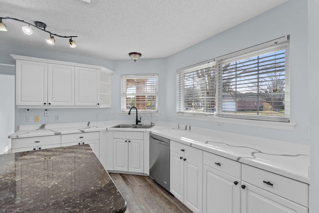 kitchen featuring light stone counters, dishwasher, white cabinets, and sink