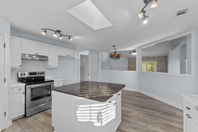 kitchen with white cabinets, stainless steel electric range oven, a kitchen island, and light hardwood / wood-style floors