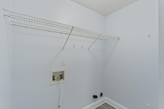 laundry area featuring washer hookup, a textured ceiling, and hardwood / wood-style floors