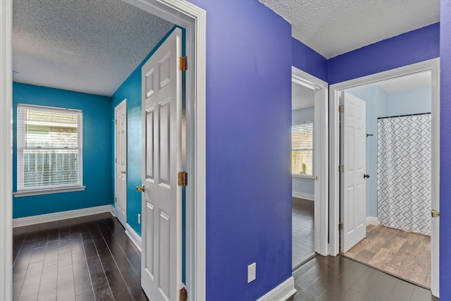 hallway featuring a textured ceiling and dark hardwood / wood-style floors