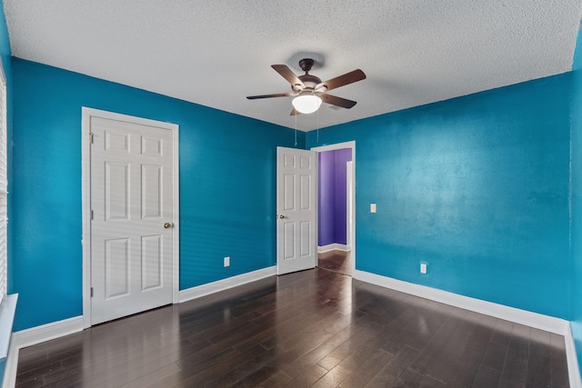 unfurnished bedroom featuring dark hardwood / wood-style flooring, a textured ceiling, and ceiling fan