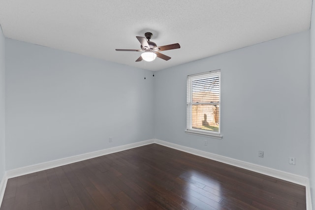 spare room with a textured ceiling and dark hardwood / wood-style floors