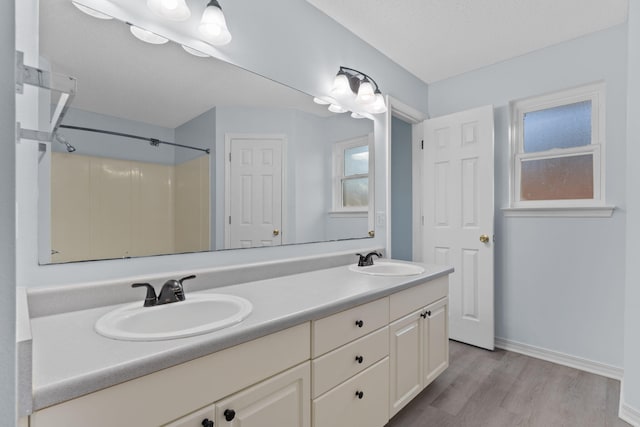 bathroom with a shower, vanity, and hardwood / wood-style flooring