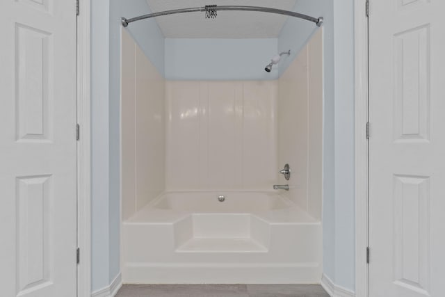 bathroom featuring a textured ceiling and shower / washtub combination