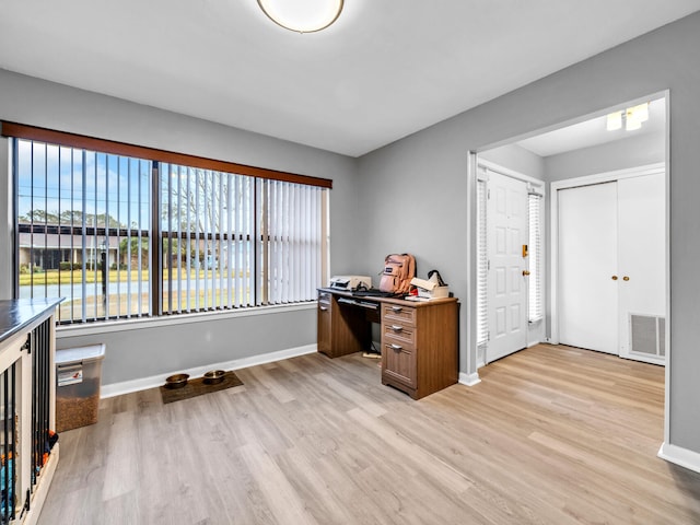 home office with light hardwood / wood-style floors