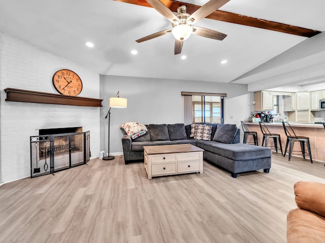 living room featuring light hardwood / wood-style floors, ceiling fan, and vaulted ceiling with beams