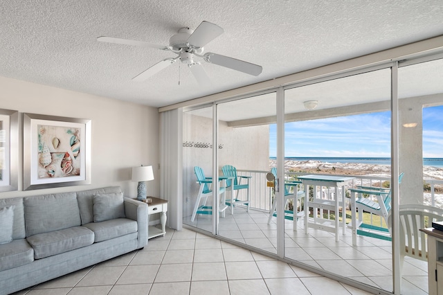 living room featuring light tile patterned flooring, ceiling fan, a wealth of natural light, and expansive windows