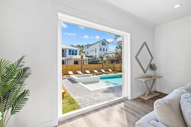 doorway to outside with plenty of natural light, ornamental molding, and light hardwood / wood-style flooring