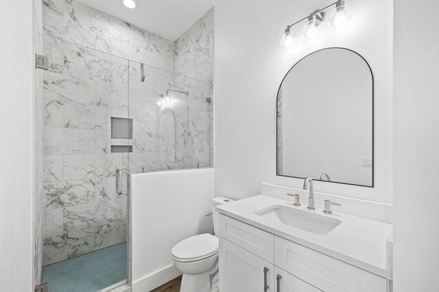 bathroom featuring vanity, toilet, and a shower with door