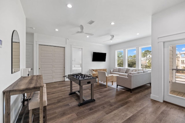 recreation room with ceiling fan and dark wood-type flooring