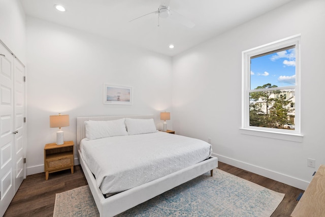 bedroom with ceiling fan, dark wood-type flooring, and a closet