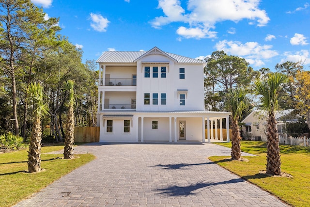 view of front of house featuring a balcony and a front lawn