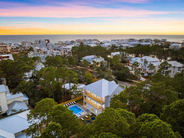 aerial view at dusk featuring a water view