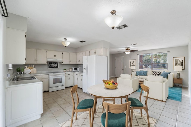 kitchen with white cabinetry, sink, light tile patterned floors, and white appliances