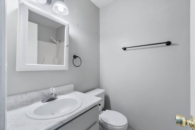 bathroom with vanity, a shower, and toilet