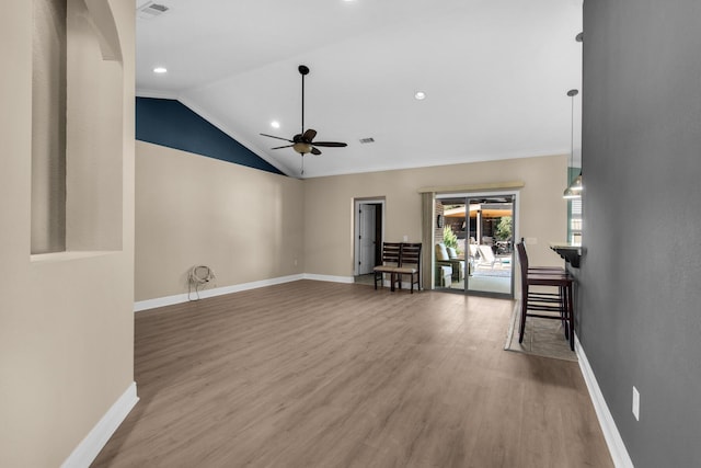 unfurnished living room with ceiling fan, ornamental molding, lofted ceiling, and hardwood / wood-style flooring