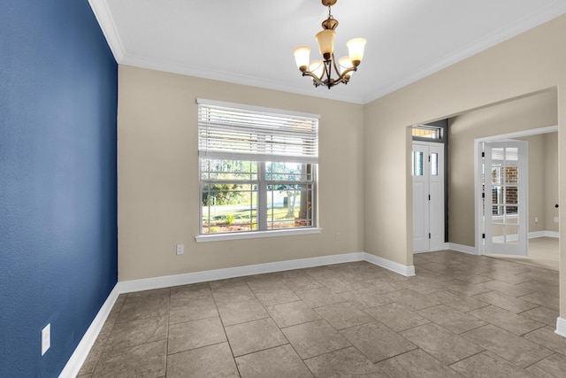 spare room with an inviting chandelier and crown molding