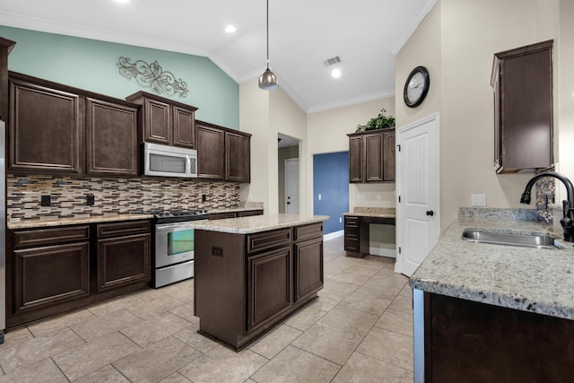 kitchen with vaulted ceiling, stainless steel appliances, a center island, ornamental molding, and sink