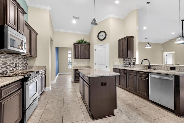 kitchen with tasteful backsplash, stainless steel appliances, a kitchen island, and hanging light fixtures