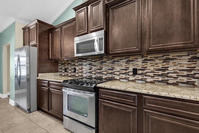 kitchen featuring stainless steel appliances, crown molding, dark brown cabinets, lofted ceiling, and tasteful backsplash