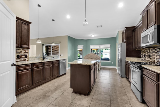 kitchen with backsplash, a center island, pendant lighting, and appliances with stainless steel finishes