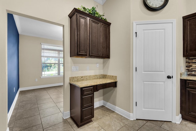 kitchen with light stone countertops, crown molding, and dark brown cabinetry