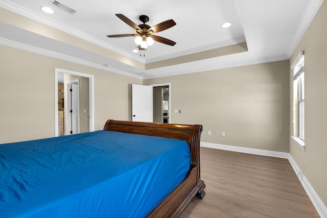 bedroom featuring ceiling fan, ornamental molding, a raised ceiling, and hardwood / wood-style flooring