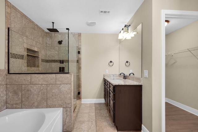 bathroom with plus walk in shower, tile patterned floors, and vanity