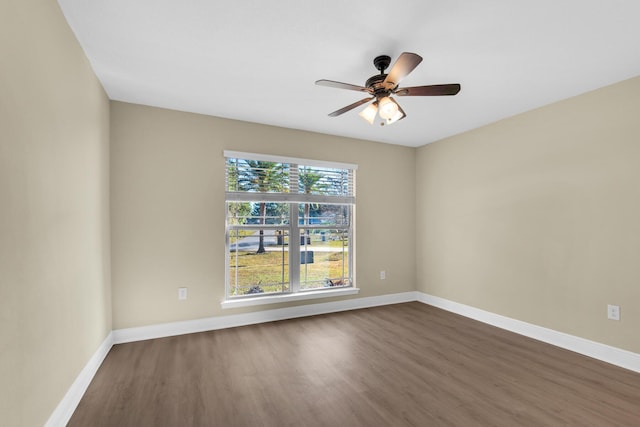 empty room with ceiling fan and dark wood-type flooring