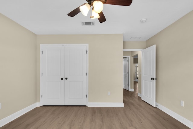 unfurnished bedroom featuring ceiling fan, light hardwood / wood-style flooring, and a closet