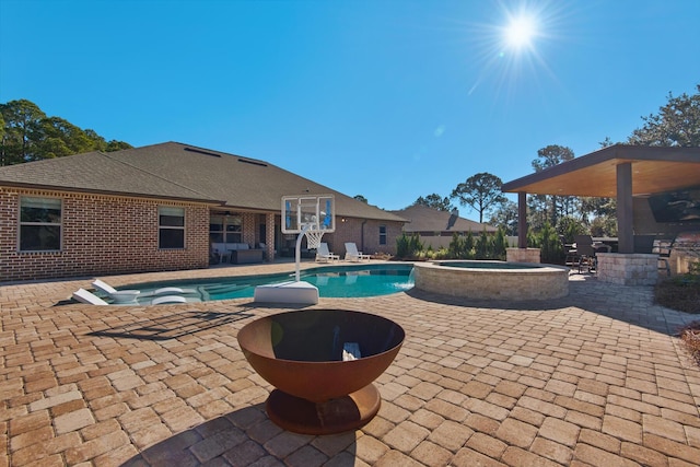 view of pool featuring a patio and an in ground hot tub