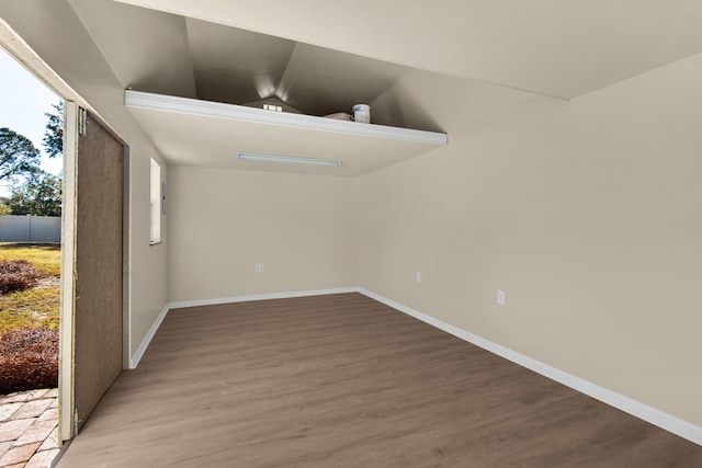 spare room with lofted ceiling and hardwood / wood-style flooring