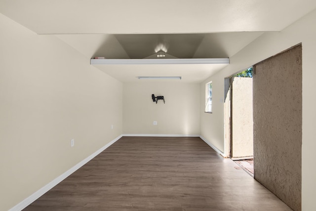 unfurnished room featuring wood-type flooring and vaulted ceiling