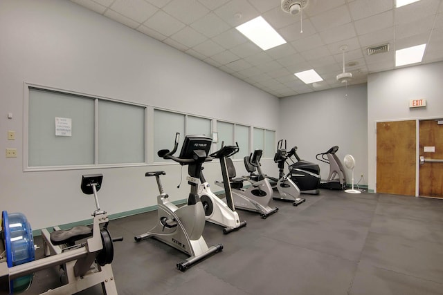 workout area with a paneled ceiling and a towering ceiling