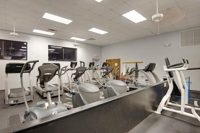 workout area featuring ceiling fan and a drop ceiling