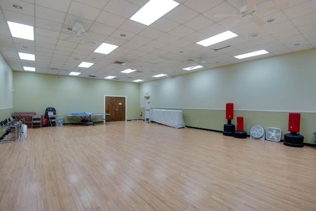 workout room with light hardwood / wood-style floors, a paneled ceiling, and ceiling fan