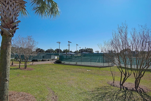 view of community with tennis court and a yard