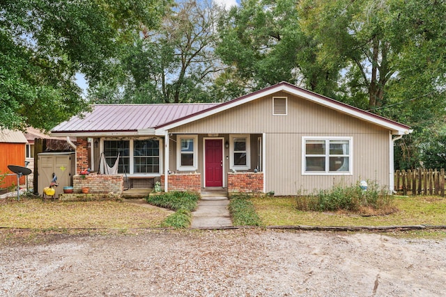 view of front of house featuring covered porch and a storage shed