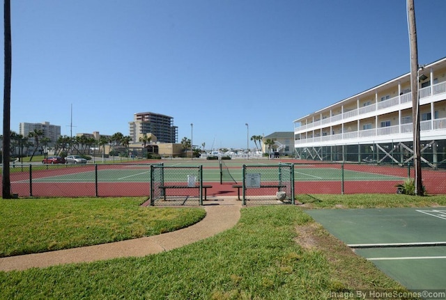 view of tennis court featuring a yard