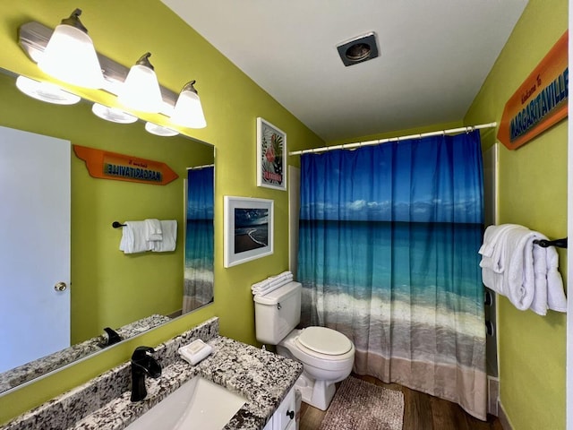 bathroom with toilet, hardwood / wood-style flooring, a shower with curtain, and vanity