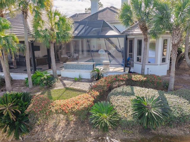 back of house featuring glass enclosure and a patio area