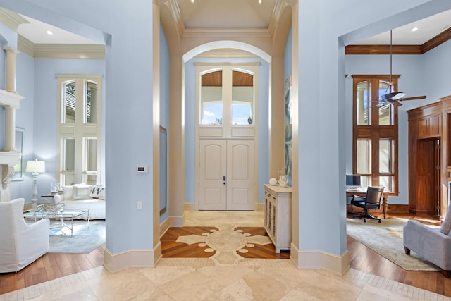 entrance foyer featuring ceiling fan, a high ceiling, and crown molding