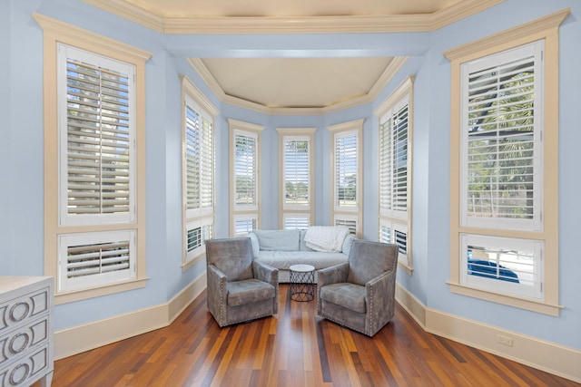 living area featuring hardwood / wood-style floors, ornamental molding, and a healthy amount of sunlight