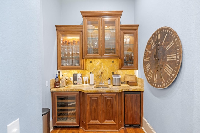 bar with light stone countertops, wine cooler, tasteful backsplash, and sink