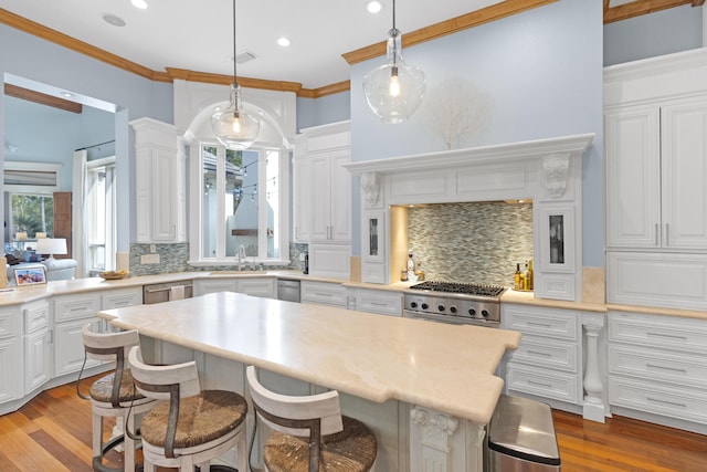 kitchen with decorative backsplash, white cabinets, and decorative light fixtures