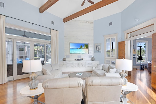 living room featuring ceiling fan, wood-type flooring, high vaulted ceiling, and beamed ceiling