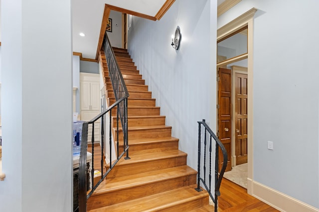 staircase with crown molding and hardwood / wood-style flooring